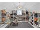 Unique walk-in closet showcasing a variety of shelves, storage, an accent chair, and a statement chandelier at 1903 S Cardenas Ave, Tampa, FL 33629