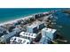 Aerial view showcasing coastal community homes, beach, marina, and ocean at 19925 Gulf Boulevard # 502, Indian Shores, FL 33785