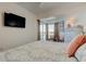 Bright bedroom with TV, balcony access, and seating near the large window at 19925 Gulf Boulevard # 502, Indian Shores, FL 33785