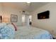 Comfortable bedroom featuring ensuite bath and TV with floral accents at 19925 Gulf Boulevard # 502, Indian Shores, FL 33785