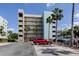 Exterior view of the condo building with palm trees and parking lot in Madeira Beach at 19925 Gulf Boulevard # 502, Indian Shores, FL 33785