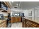 Granite countertops and wooden cabinets in the kitchen with bar seating open to living room at 19925 Gulf Boulevard # 502, Indian Shores, FL 33785
