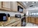 Charming kitchen featuring granite countertops, wood cabinetry, and stainless steel appliances at 19925 Gulf Boulevard # 502, Indian Shores, FL 33785