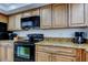 Well-lit kitchen boasting granite countertops, ample cabinet space, and modern black appliances at 19925 Gulf Boulevard # 502, Indian Shores, FL 33785
