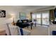 Living room with a leather sofa, patterned chairs, and sliding glass doors to a balcony at 19925 Gulf Boulevard # 502, Indian Shores, FL 33785