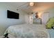 Bright main bedroom featuring a ceiling fan, TV, closet, and dresser for ample storage at 19925 Gulf Boulevard # 502, Indian Shores, FL 33785