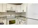 Efficient kitchen with granite countertops, modern appliances, and white cabinets at 2007 W De Leon St # C, Tampa, FL 33606