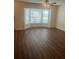 Bright living room features sleek wood floors, a ceiling fan, and a large bay window with blinds at 2007 W De Leon St # C, Tampa, FL 33606
