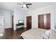 Cozy bedroom with hardwood floors, ceiling fan, television, and a double closet at 215 Central Ave # 4F, St Petersburg, FL 33701
