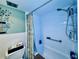 Bright bathroom features a shower-tub combination, grab bar, and storage shelving at 2348 Shelley St # 13, Clearwater, FL 33765