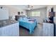 Bright bedroom features a blue comforter, ceiling fan, dresser, and neutral walls, creating a serene atmosphere at 2348 Shelley St # 13, Clearwater, FL 33765