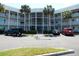 Three-story condo with a white facade, supported by palm trees at 2449 Columbia Dr # 53, Clearwater, FL 33763