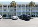 Three-story condo with white facade and palm trees in the parking lot at 2449 Columbia Dr # 53, Clearwater, FL 33763