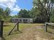 View of the property, surrounded by natural landscapes and partially enclosed by a rustic fence at 265 Corbett Rd, Lithia, FL 33547