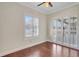 Bedroom with hardwood floors, ceiling fan, and shuttered sliding doors at 2863 Duncan Tree Cir, Valrico, FL 33594
