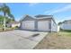Side view of house with large concrete driveway and three car garage on a sunny day at 2863 Duncan Tree Cir, Valrico, FL 33594