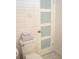 Clean white bathroom with frosted glass paneled door, stacked towels and white subway tile at 340 81St Ave, St Pete Beach, FL 33706