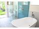 Bright bathroom with a freestanding tub, walk-in shower and an open door to a lawn at 340 81St Ave, St Pete Beach, FL 33706