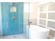 Bathroom with a freestanding tub, walk-in shower with blue tile and sliding doors at 340 81St Ave, St Pete Beach, FL 33706