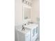 White bathroom vanity with white cabinets, drawer storage, polished chrome faucet and white framed mirror at 340 81St Ave, St Pete Beach, FL 33706