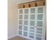 Built in wardrobe with white doors, frosted glass and decorative baskets on top at 340 81St Ave, St Pete Beach, FL 33706