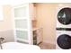 Laundry area featuring white cabinets, modern washer/dryer, and frosted glass sliding doors at 340 81St Ave, St Pete Beach, FL 33706
