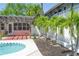 Outdoor pool and patio area with tropical landscaping, pergola, and cozy seating at 340 81St Ave, St Pete Beach, FL 33706