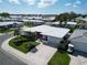 An aerial view showcases this home's pristine white roof and lush surrounding community at 3800 101St N Ter # 3800, Pinellas Park, FL 33782