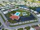 Aerial view of the community pool, clubhouse, parking, and shuffleboard near a pond at 3800 101St N Ter # 3800, Pinellas Park, FL 33782
