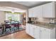 Elegant kitchen with granite countertops, white cabinetry, and a view into the adjacent dining area at 3800 101St N Ter # 3800, Pinellas Park, FL 33782