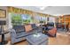 Comfortable living room with large windows offering views of lush greenery and a cozy seating area at 3800 101St N Ter # 3800, Pinellas Park, FL 33782