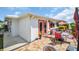 Charming outdoor brick patio area with outdoor dining set, umbrella, and lush green landscaping at 3800 101St N Ter # 3800, Pinellas Park, FL 33782