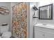 Well-lit bathroom featuring a floral shower curtain, floating shelves, and a sleek, modern vanity at 3803 Cortez Cir # C, Tampa, FL 33614