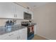 Updated kitchen featuring granite countertops, white cabinets, and stainless steel appliances at 3803 Cortez Cir # C, Tampa, FL 33614