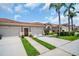 Townhome featuring a terra cotta roof, attached garages, and meticulous landscaping at 3885 Timber Ridge Ct, Palm Harbor, FL 34685
