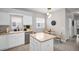 White kitchen featuring an island, stainless appliances, and an adjacent breakfast nook at 3885 Timber Ridge Ct, Palm Harbor, FL 34685