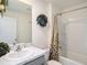 A well-lit bathroom includes a vanity with a marble countertop and a shower with a leaf-patterned curtain at 4114 Dovetail Ln, Palmetto, FL 34221