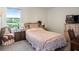 Bedroom featuring a bed with a floral patterned bedspread and adjacent window at 4114 Dovetail Ln, Palmetto, FL 34221