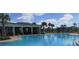Large community pool and covered outdoor seating area featuring lounge chairs for residents to relax and unwind at 4114 Dovetail Ln, Palmetto, FL 34221