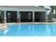Community pool featuring a covered outdoor seating area with high-top and traditional tables and chairs for residents at 4114 Dovetail Ln, Palmetto, FL 34221