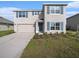 Charming two-story home featuring blue shutters, a well-manicured lawn, and an attached two-car garage at 4114 Dovetail Ln, Palmetto, FL 34221