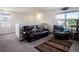 A comfortable living room with a leather sofa, recliner, and a view of the neighborhood at 4114 Dovetail Ln, Palmetto, FL 34221