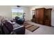 This living room includes a leather recliner, wooden shelving, and a view of a lake at 4114 Dovetail Ln, Palmetto, FL 34221