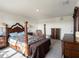 Large main bedroom featuring a beautifully decorated four-poster bed, dresser, and a light fixture at 4114 Dovetail Ln, Palmetto, FL 34221