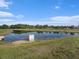 Scenic view of the community pond surrounded by lush greenery and clear blue skies at 4114 Dovetail Ln, Palmetto, FL 34221