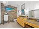 Bathroom features a stone accent wall, yellow vanity, and decorative mirrors at 475 2Nd N St # 201, St Petersburg, FL 33701
