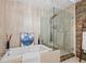 A bathroom with a bathtub and stand-up shower with a stone wall at 475 2Nd N St # 201, St Petersburg, FL 33701