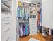 A walk-in closet with an adjustable ladder, hanging clothes, and storage containers at 475 2Nd N St # 201, St Petersburg, FL 33701