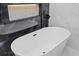 Freestanding tub and dark marble tile in updated bathroom at 504 Driftwood E Dr, Palm Harbor, FL 34683