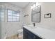 Bathroom featuring a blue vanity, marbled tile, and black fixtures at 504 Driftwood E Dr, Palm Harbor, FL 34683